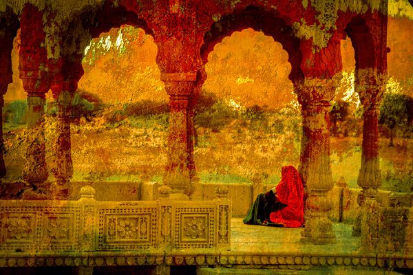 Mujer vestida de rojo bajo las arcadas de un palacio